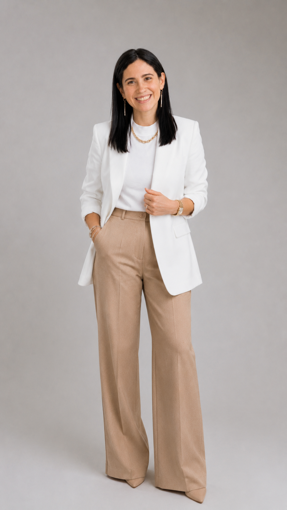 Desiree Menendez, EA, founder of Menendez Vet Financial Group, standing in a white blazer and tan trousers against a warm gray backdrop.